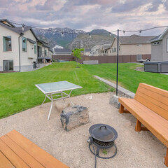 Square Puffy clouds at sunset Outdoor lounge with two wooden benches and covered fire pit