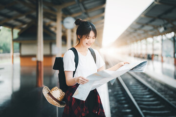 summer, relax, vacation, travel, portrait of a cute Asian girl looking at a map to plan a trip...