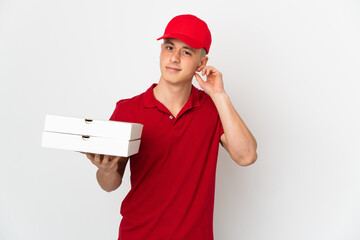 Pizza delivery man with work uniform picking up pizza boxes isolated on white background having doubts