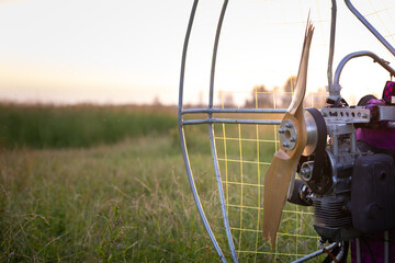 Broken wooden propeller of a gasoline-powered paraglider after a failed landing in the evening sun...