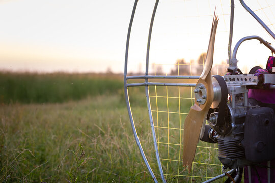 Broken wooden propeller of a gasoline-powered paraglider after a failed landing in the evening sun at sunset. Paragliding for individual paragliding flights. Extreme sports.