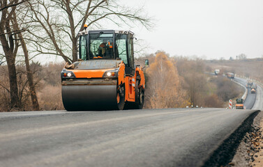 Vibratory asphalt rollers compactor compacting new asphalt pavement. Road service build a new highway