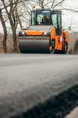 Vibratory asphalt rollers compactor compacting new asphalt pavement. Road service build a new...