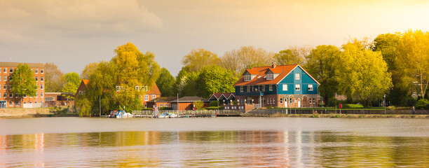 Panorama of colorful house and trees at the Leda river in Leer, Germany
