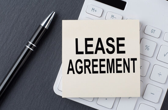 Text LEASE AGREEMENT on the sticker on the calculator, business concept