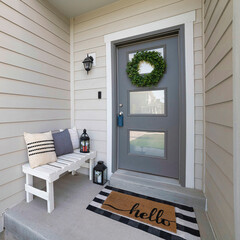 Square Small front porch with white bench and gray front door