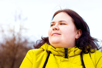 Happy attractive chubby overweight Caucasian woman smiling portrait outdoors. Cheerful pretty body positive person laughing during walk in the park.
