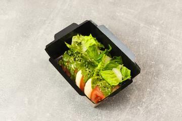 Fresh italian caprese salad with mozzarella and tomatoes on gray background.	