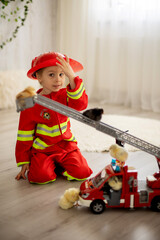 Little toddler child, playing with fire truck car toy and little chicks at home