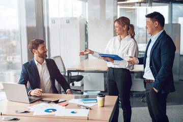 Beautiful business people are using gadgets, talking and smiling during the conference in office. 