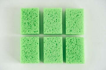 Green sponges for cleaning on a white background