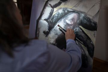 Close-up of a mature artist woman spending her leisure time developing her painting skills at her workshop