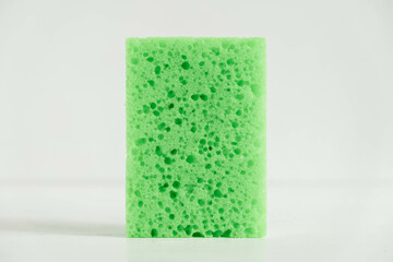 Green sponge for cleaning on a white background