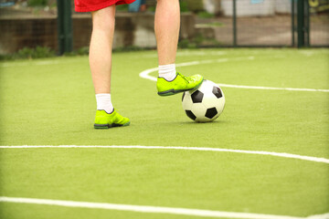 Obraz premium Players play mini football on the field. Legs, sneakers and a ball. Green football field.