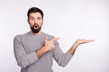 Photo of young man amazed shock omg point finger product offer select isolated over grey color...