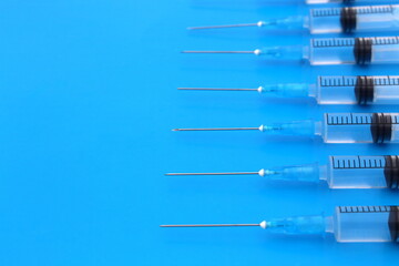 Injection syringes lie on a blue background with space for text.