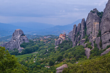 Fototapeta na wymiar View of Monastery of St. Nicholas Anapavsas on top of a sheer cliff. The miracle of Meteora - harmony of man and nature in Greece. A popular travel and pilgrimage destination