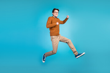 Fototapeta na wymiar Full size photo of young excited man good mood jump up active walk run isolated over blue color background