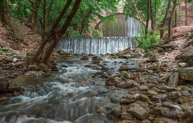 The historical stone arched bridge of Palaiokarya with its two artificial waterfalls, creates a magnificent, inspiring image.