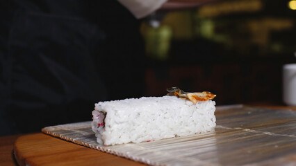 Close-up cooking rice sushi roll. Frame. Close-up of chef of oriental cuisine in gloves preparing...