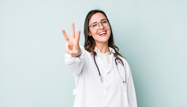 young pretty woman  smiling and looking friendly, showing number three. physician concept