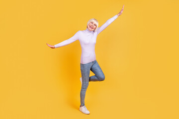 Fototapeta na wymiar Full size photo of cheerful mature woman have fun excited dance free-time isolated over yellow color background