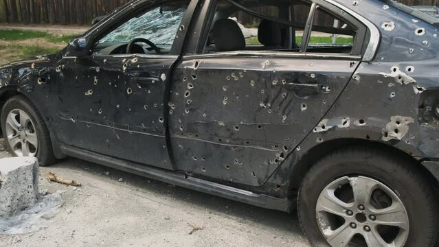 Irpin, April 2022, burnt in a shelled car in a parking lot. War in Ukraine, cutting frames of broken cars. 