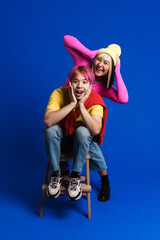 Asian couple with multicolored hair making fun together