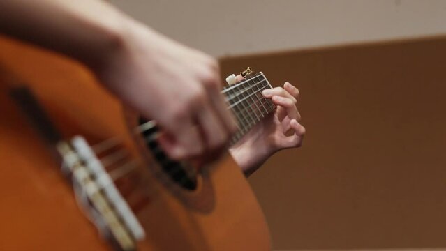 Young boy playing guitar indoors at school.