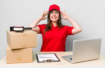 young pretty woman  feeling stressed, anxious or scared, with hands on head. company packer employee