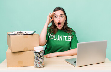 young pretty woman  looking happy, astonished and surprised. volunteer donation concept