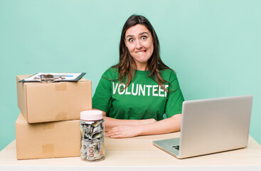 young pretty woman  looking puzzled and confused. volunteer donation concept
