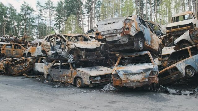 Irpin, a lot of burned-out shelled cars in the parking lot on top of each other in the middle of the forest, the consequences of the invasion of the Russian army in Ukraine. War in Ukraine
