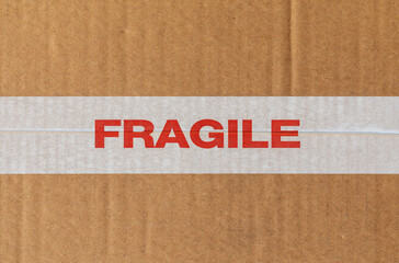 Fragile white tape on cardboard texture