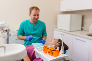 Dental glasses for UV protection. Against the background of the doctor and the patient.