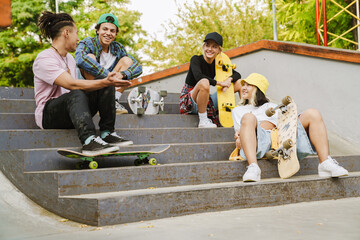 Multiracial teenagers talking while spending time at skate park © Drobot Dean
