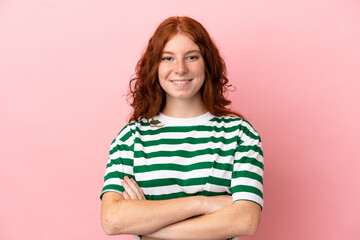 Fototapeta premium Teenager redhead girl over isolated pink background keeping the arms crossed in frontal position
