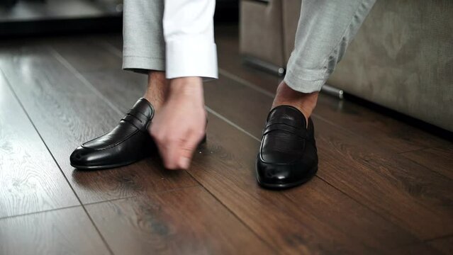 a man puts on black classic shoes for a holiday, close-up