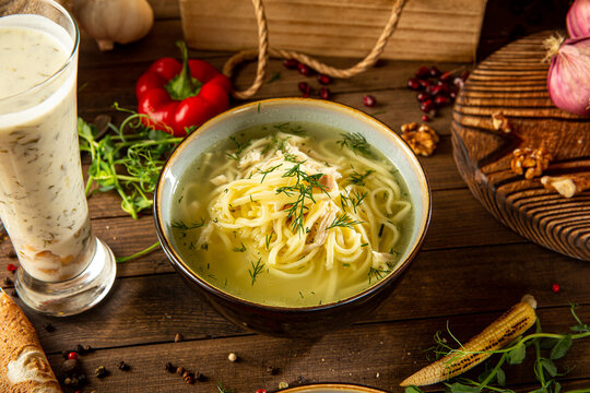 Chicken noodle soup with dovga soup on wooden table 