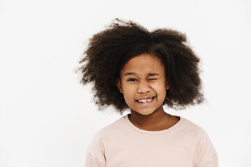 Black preteen girl with curly hair smiling and winking at camera