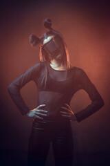 Portrait of beautiful cyber model woman posing wearing futuristic glasses on head with neon light...