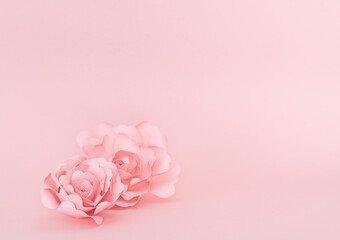 Paper roses on pink background. Copy space.