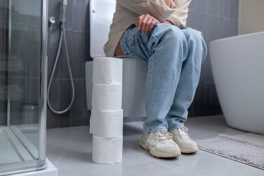 A young woman sitting on a toilet bowl