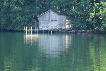 Obraz premium A Secluded Wooden Boat House on a Lake Side.