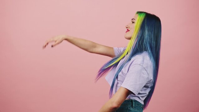 Young woman going back with waving hands, pointing fingers to camera and smiling and keep moving, free space