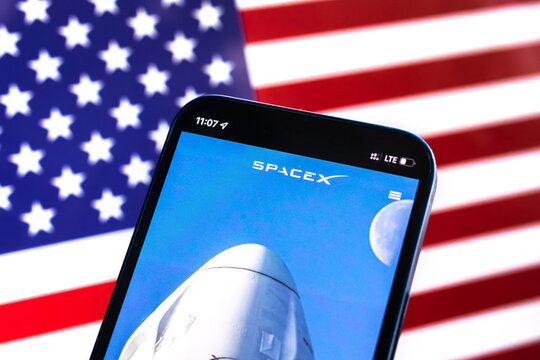 SpaceX logo against American flag, USA background. Satellite internet modern technology provided by Elon Musk