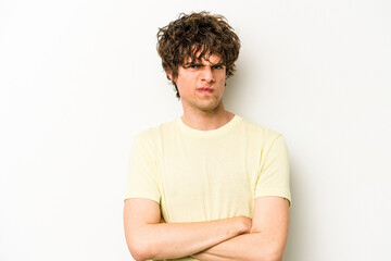 Obraz premium Young caucasian man isolated on white background frowning face in displeasure, keeps arms folded.