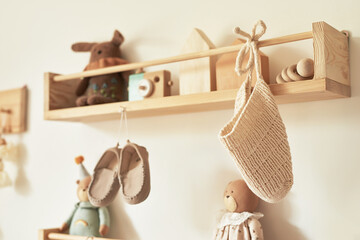 Children's knitted clothes on hanger. Jacket, jumper, hat, shoes. toys. Children's room, nursery