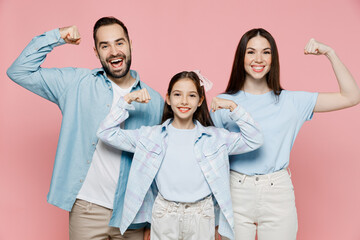 Young parents mom dad with child kid daughter teen girl in blue clothes showing biceps muscles on...