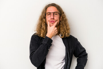 Young caucasian man isolated on white background doubting between two options.